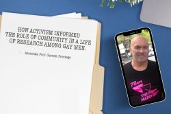 Top-down image of a blue desk top, with a phone showing a picture of Garrett Prestage in a '78ers: the first Mardi Gras' T-shirt, alongside a sheet of paper on a manila folder titled 'How activism informed the role of community in a life of research among gay men'