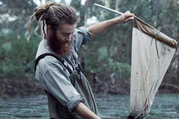 Man standing in water and filtering it
