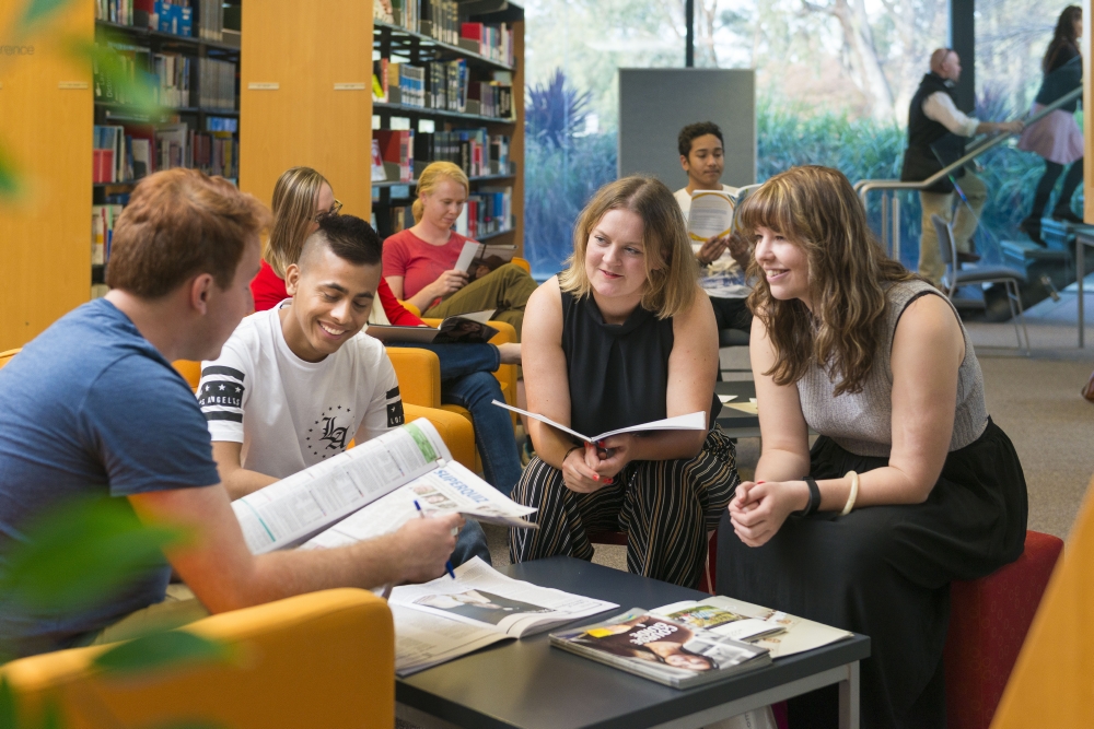 Group of students socialising and studying in the David Mann Library