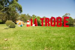 Giant letters spelling 'La Trobe' on the lawn with beach umbrellas and deck chairs