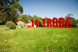 Giant letters spelling 'La Trobe' on the lawn with beach umbrellas and deck chairs