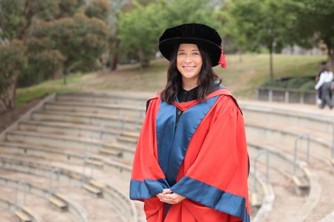 academic standing in academic gown outdoors
